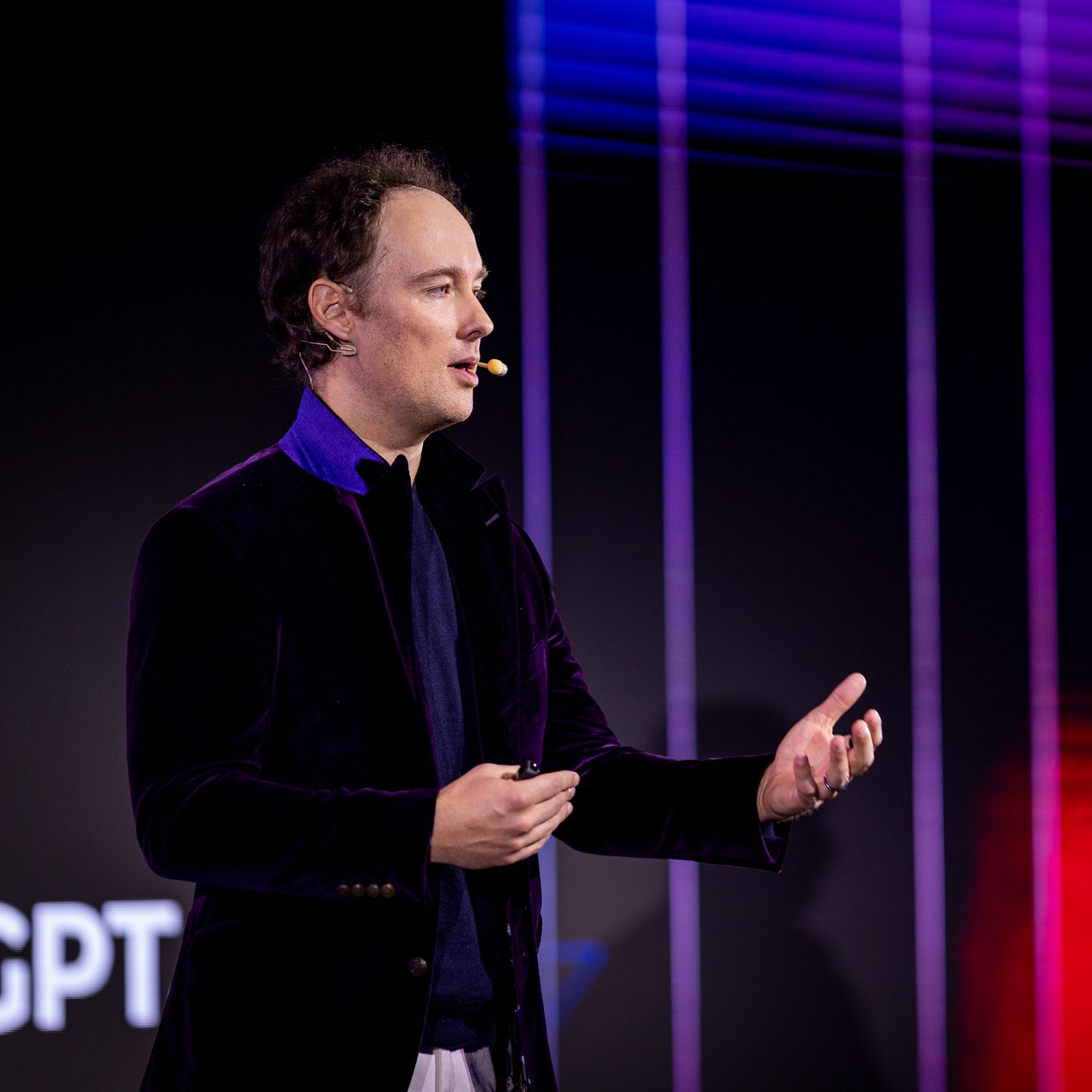 Martynas Kairys kalba HR savaitės 2026 scenoje, gestikuliuoja, prie skruosto mikrofonas