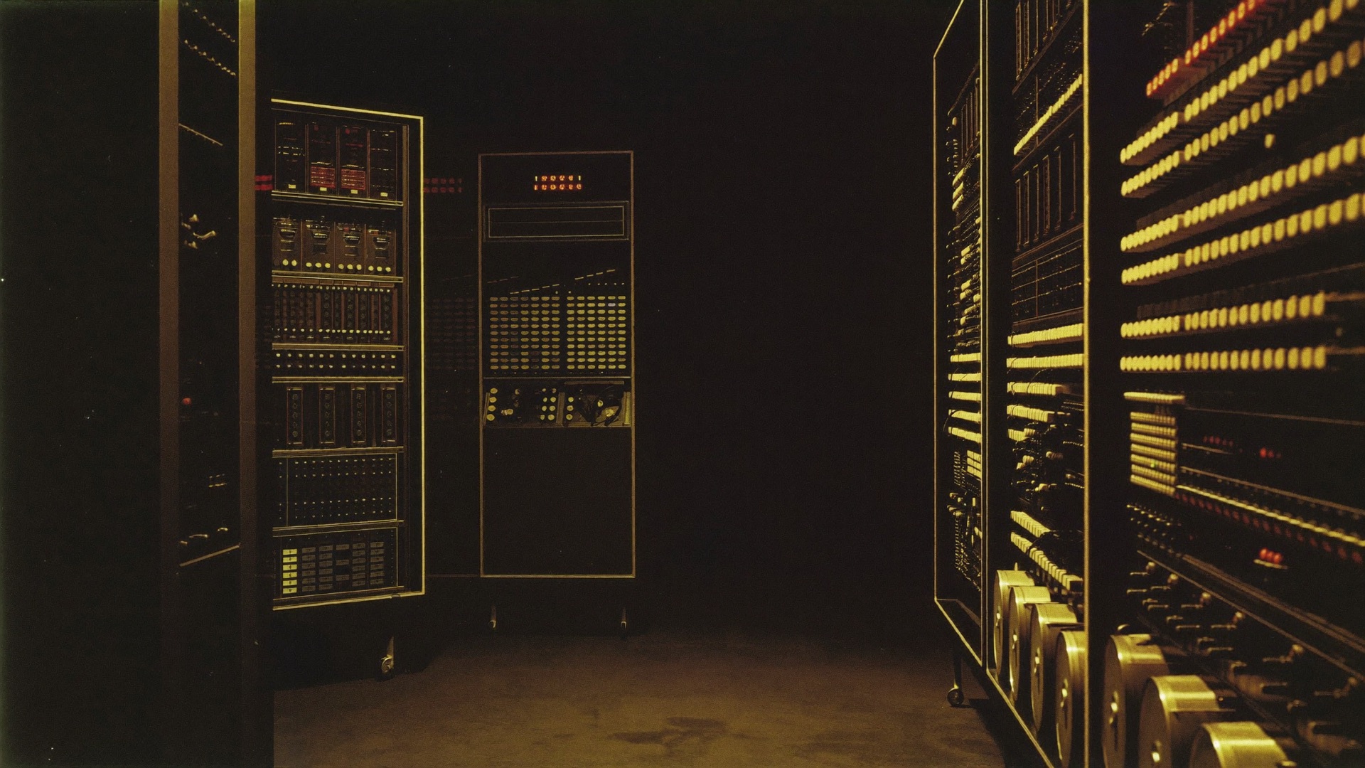 Racks of vacuum tubes glowing amber in a dark 1950s computer room