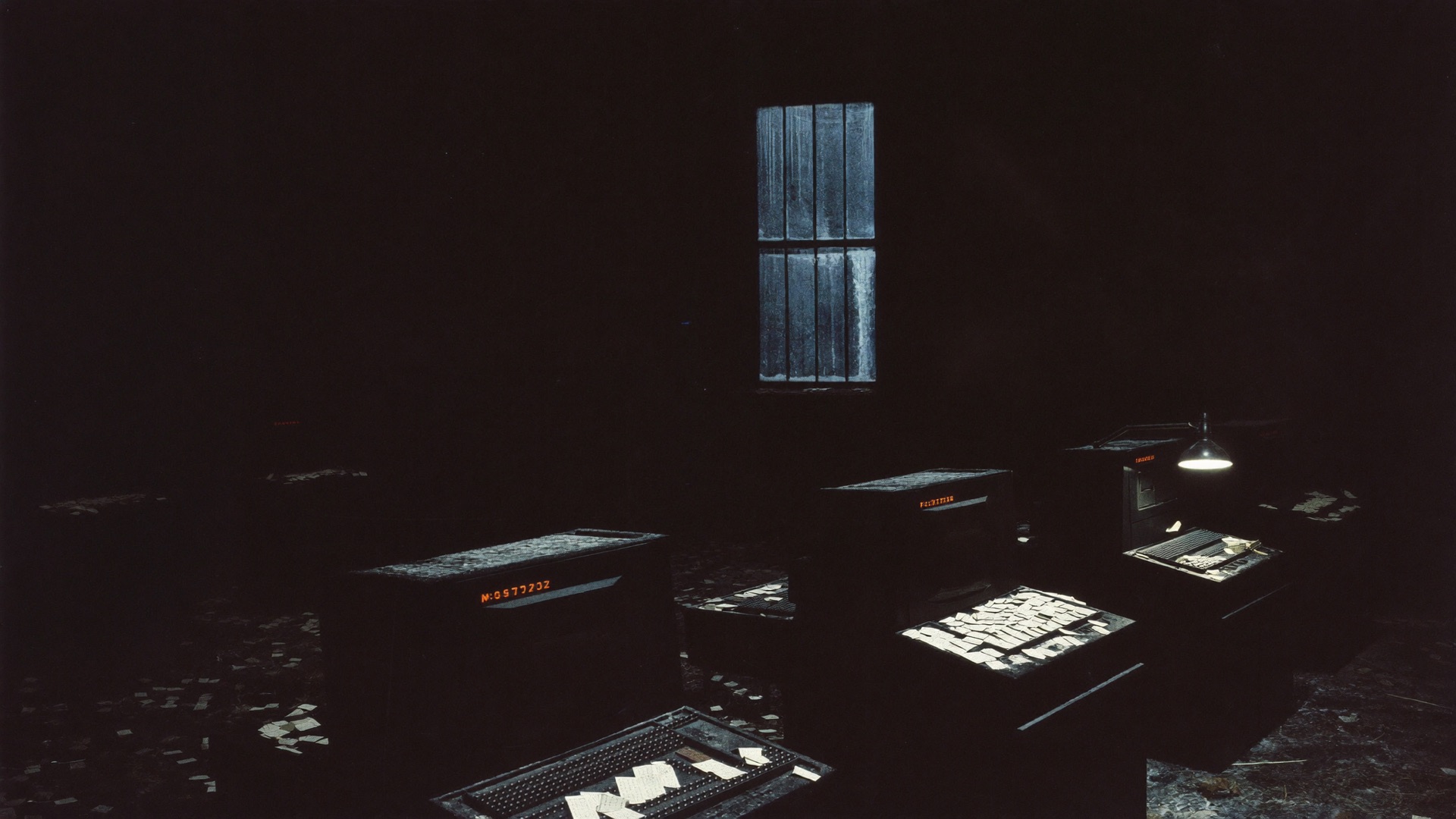 An abandoned 1970s computer laboratory in cold darkness with scattered punch cards