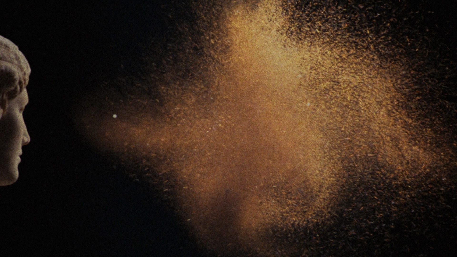 A nebula of golden particles condensing beside a classical marble profile